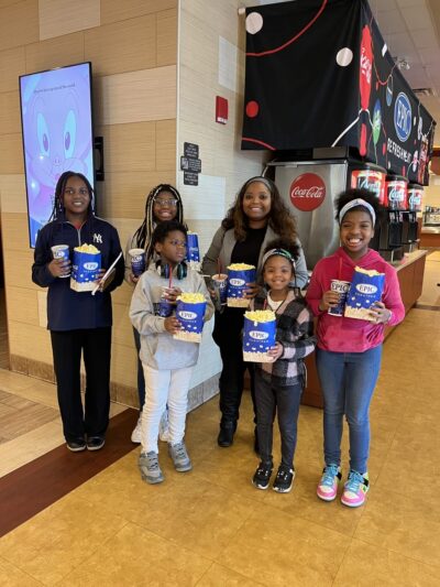 فتيات يبتسمن في السينما مع الفشار